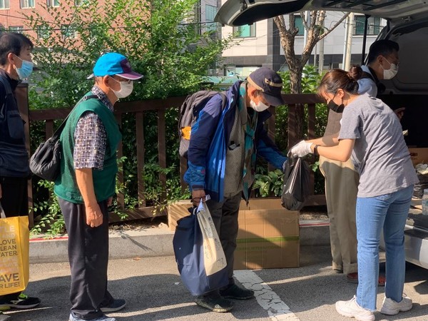 사회적 거리두기 2.5단계 전, 코로나 감염증 예방으로 바하밥집은 현장배식에서 게릴라 배식으로 전환했다. 바하밥집 활동가들이 거리에서 게릴라 배식을 하고 있는 장면. (사진: 바하밥집 제공)