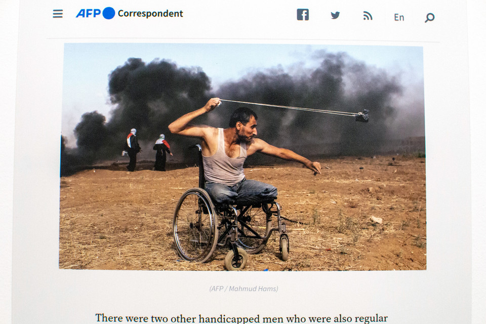 〔사진 #1〕 휠체어를 탄 남성이 돌팔매를 돌리고 있다. (Mahmud Hams/AFP)<br>