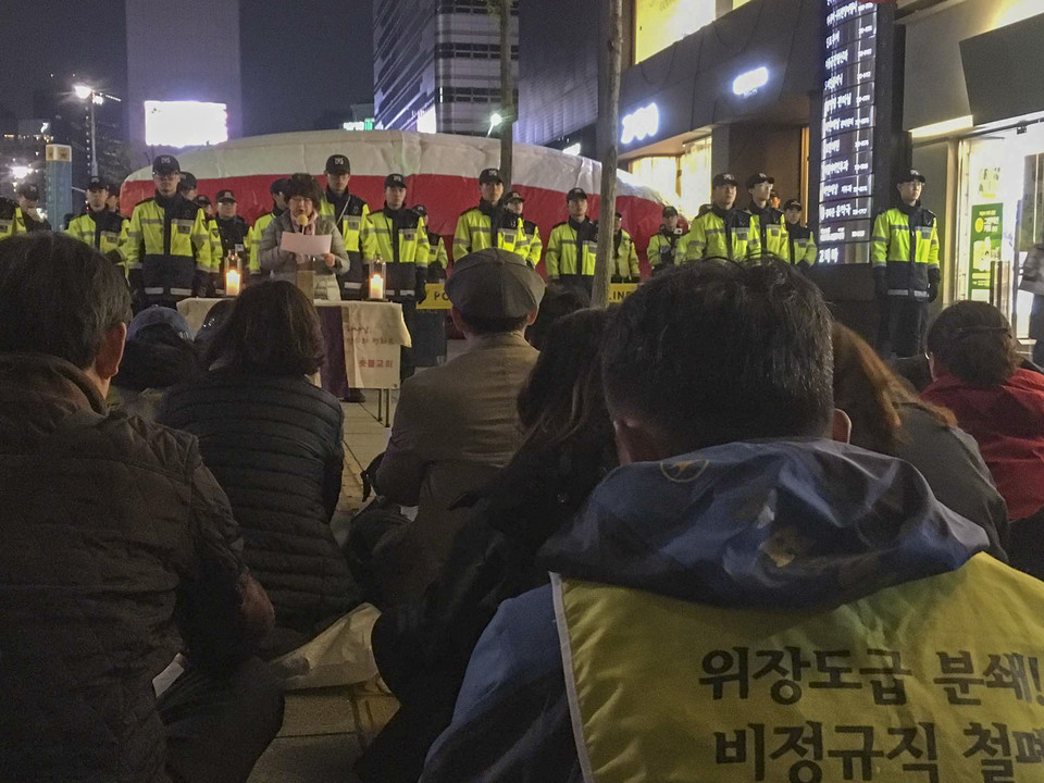 2017년 4월 14일 ‘비정규직 철폐’를 요구하는 해직·비정규직 노동자들이 세종로 세광빌딩 옥상 광고탑에 올라 고공농성에 돌입했다. 광고탑 아래 지상에 사람들이 모여 기도회를 진행하고 있다. (사진: 필자 제공)<br>