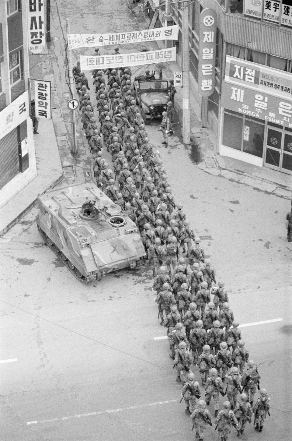 계엄군이 행군하는 금남로 건물 사이에 ‘침례교 한미전도대회’를 알리는 펼침막이 걸려있다. (사진: 나경택, 5·18기념재단 제공)